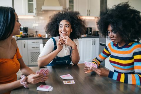 tři dívky doma hrají karty