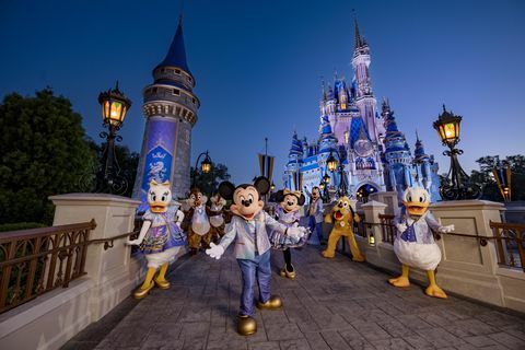 mickey mouse a přátelé v třpytivé módě k 50. výročí při pózování před zámkem Popelky v parku kouzelného království