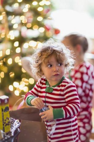 kavkazské chlapeček otevření dárek u vánočního stromu